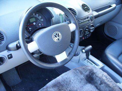 2003 Volkswagen Beetle - Interior view of a 2003 Volkswagen Beetle, highlighting the dashboard and driver's controls.