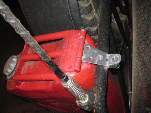 1909 Ford Bronco - A red jerrycan is mounted to the vehicle with a metal strap and a spring-loaded mechanism.