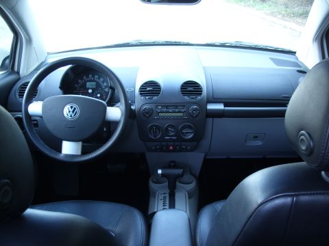 2003 Volkswagen Beetle - The interior of a Volkswagen Beetle shows the dashboard, steering wheel, and front seats.