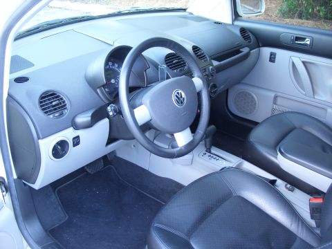 2003 Volkswagen Beetle - The interior of a 2003 Volkswagen Beetle, black leather seats and a grey dashboard.
