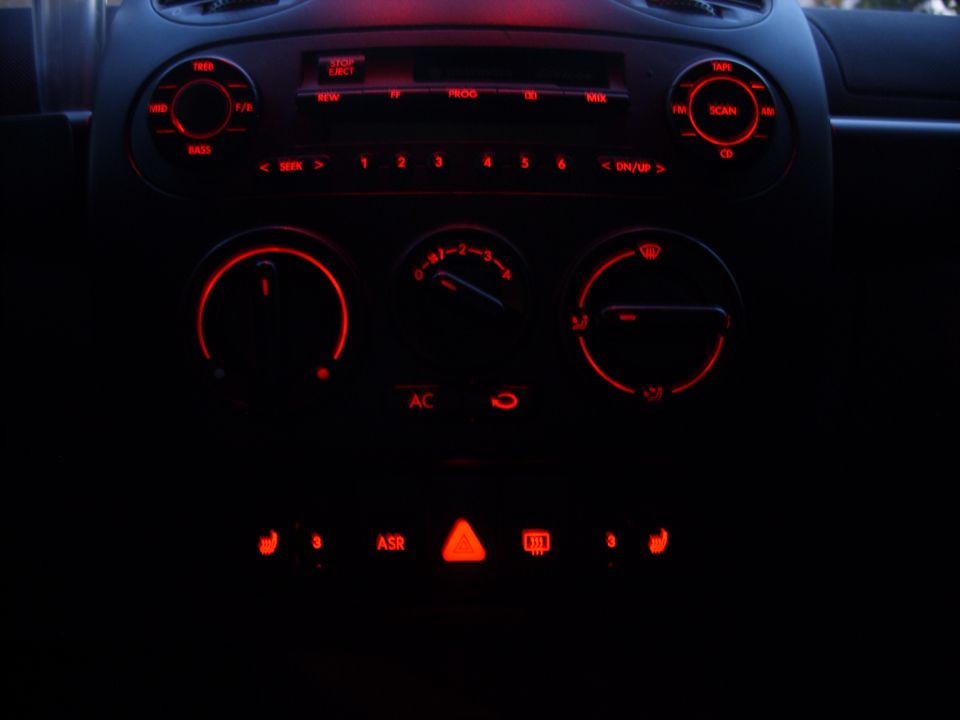 Dashboard with glowing red interior lights and controls