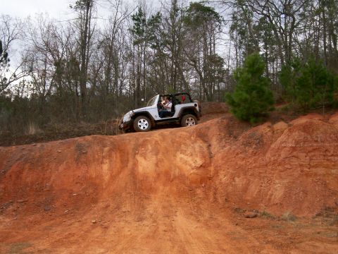 1993 Ford Bronco - Jeep Wrangler navigates a challenging off-road trail with steep inclines.