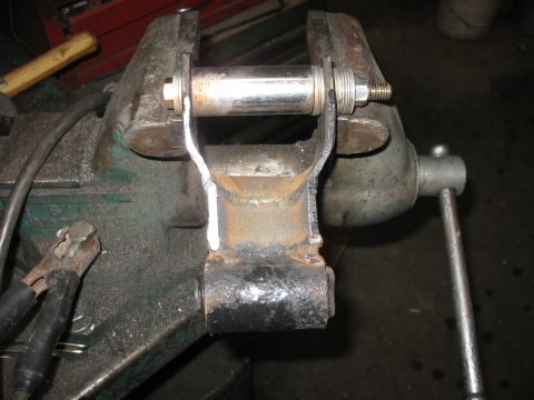 1995 Ford C-350 (Centurion Conversions) - A leaf spring shackle is clamped in a vise, ready for work.