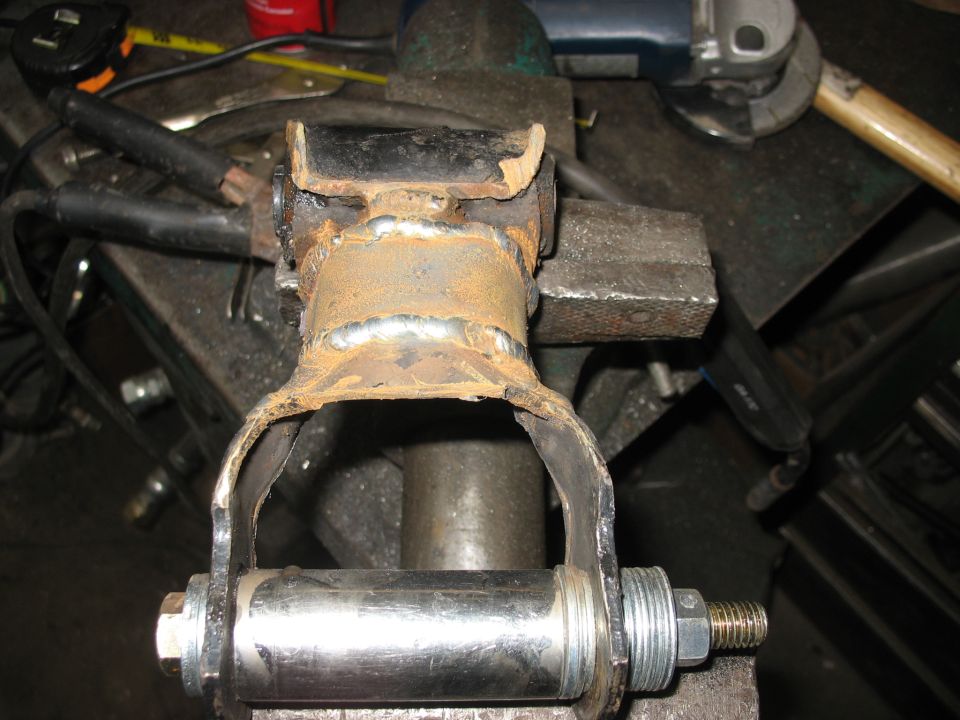 Rusty suspension component with new bolt and nut clamped in a vise
