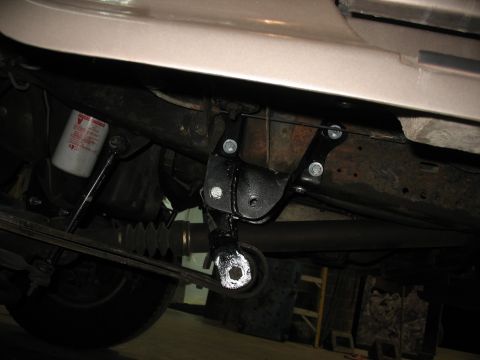 1995 Ford C-350 (Centurion Conversions) - Underside view of a vehicle's suspension system, showing a newly installed bracket and an oil filter.