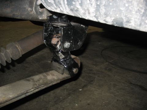 1995 Ford C-350 (Centurion Conversions) - This photo shows a close-up of a vehicle's suspension system, focusing on a bracket and leaf spring.
