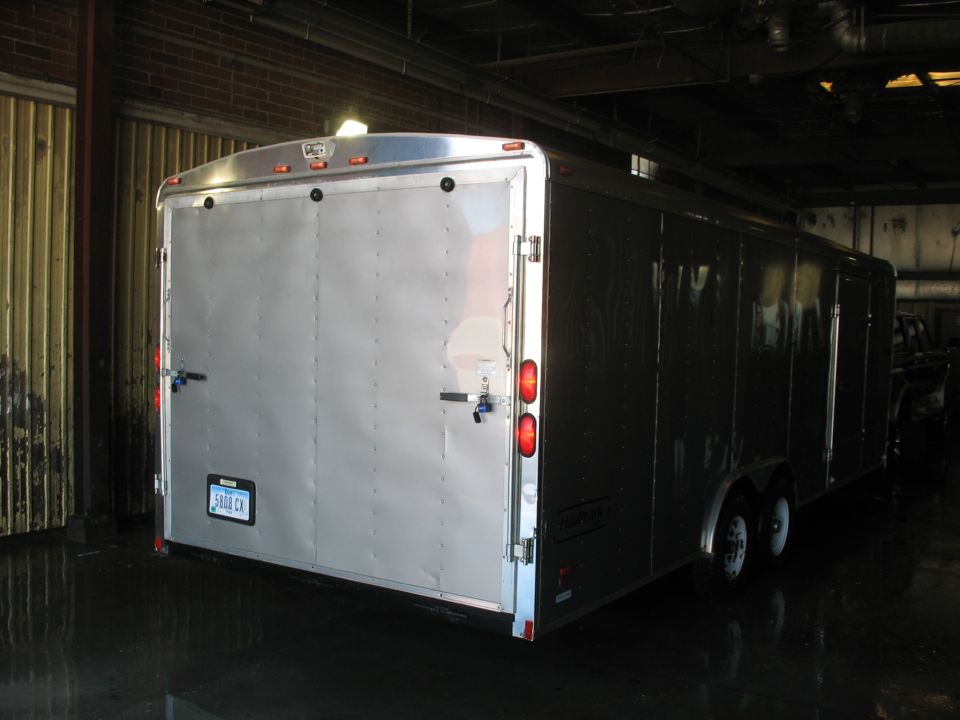 Silver enclosed trailer rear view with double doors and license plate