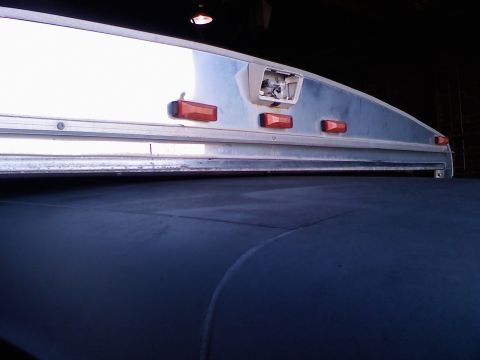 1995 Ford C-350 (Centurion Conversions) - The top rear of a trailer is shown, amber marker lights and a damaged housing for a camera or light.