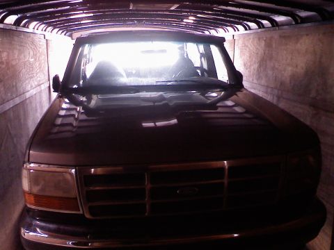 1995 Ford C-350 (Centurion Conversions) - Interior view of a dark-colored SUV, possibly from the 1990s, parked inside a trailer.