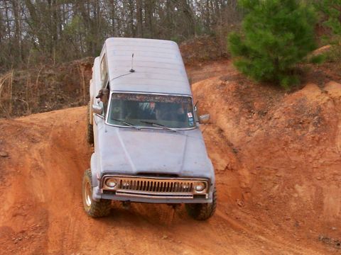 1993 Ford Bronco - This Jeep Cherokee XJ is navigating a steep, muddy incline on an off-road trail.