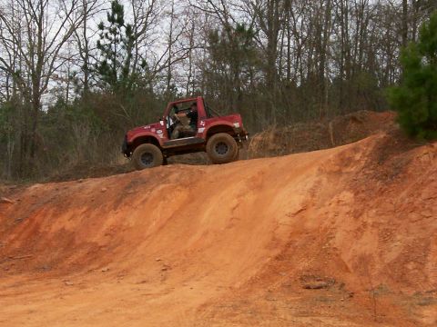 1993 Ford Bronco - Off-road vehicle navigates a challenging dirt incline during an outdoor excursion.