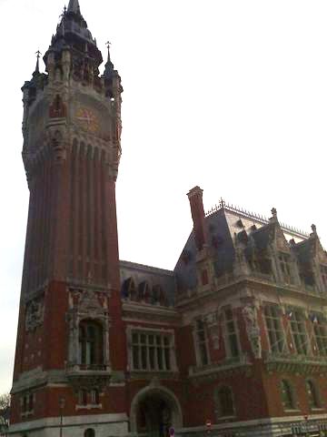 1991 Ford LTD Crown Victoria - A grand building with a prominent clock tower stands against a clear sky, displaying intricate architectural details.