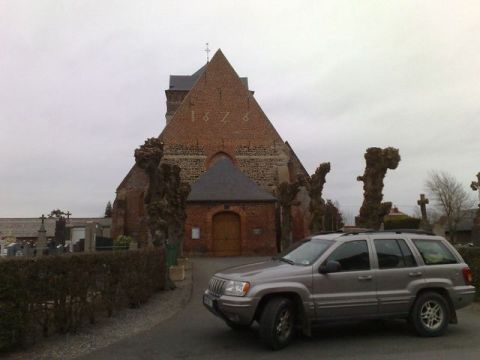 1991 Ford LTD Crown Victoria - A silver Jeep Grand Cherokee is parked in front of a historic brick church, with a cemetery visible to the left.