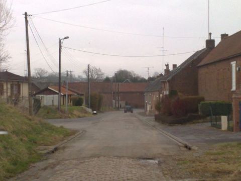 1991 Ford LTD Crown Victoria - A lone vehicle travels through a quiet European village on an overcast day.