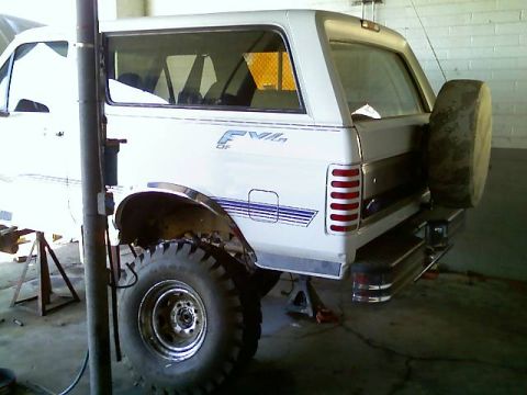 1996 Ford Bronco - Rear view of a white 1996 Ford Bronco, showing its spare tire mounted externally.