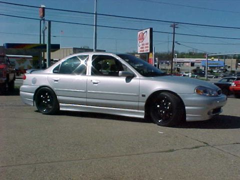 2000 Ford Contour - A silver 2000 Ford Contour sedan is seen from a three-quarter front angle, parked outdoors.