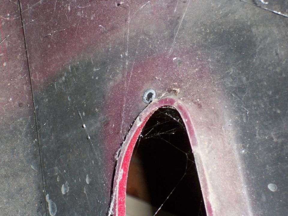 close-up of a car's red wheel well interior with cobwebs