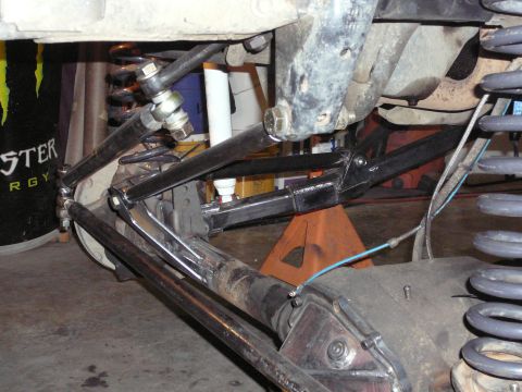1991 Ford Bronco - Close-up view of custom suspension linkage and coil springs on a vehicle's undercarriage.