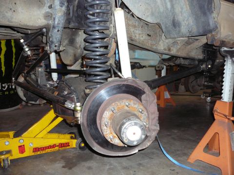 1991 Ford Bronco - Close-up of a vehicle's front suspension and axle, showing heavy-duty components and aftermarket modifications.