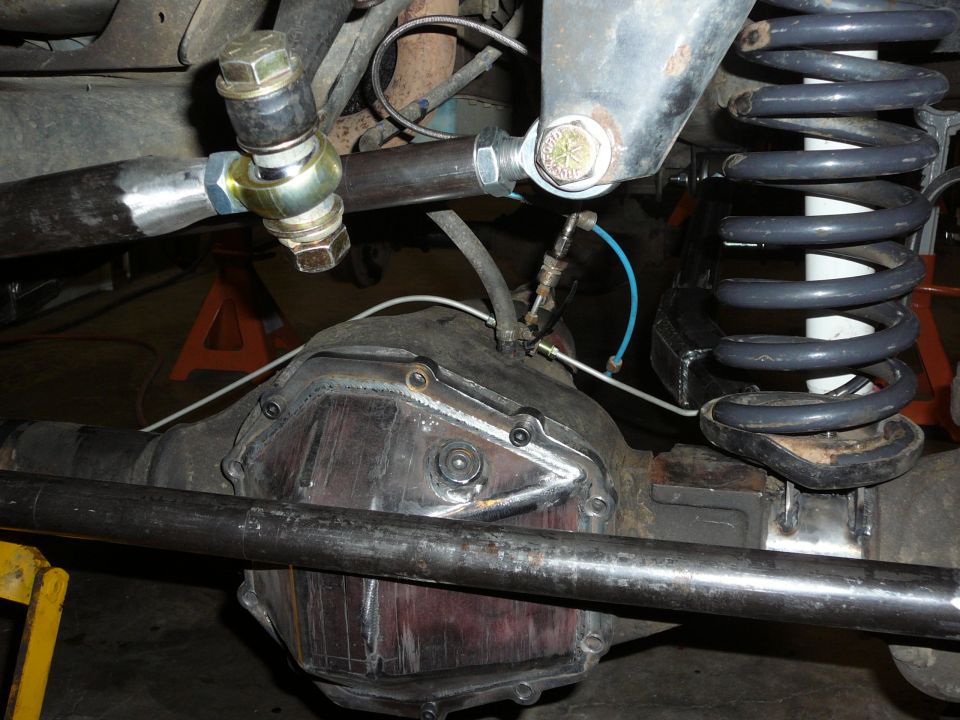 Rear axle assembly with suspension linkage and coil spring