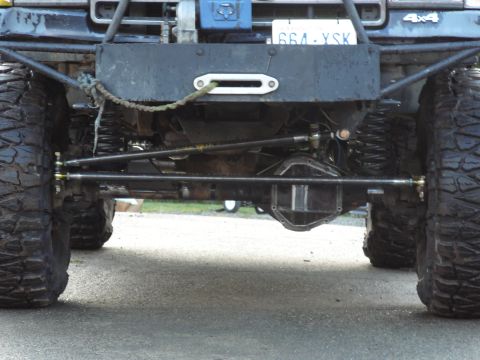 1991 Ford Bronco - This modified truck's front suspension and axle are visible, along with a winch and license plate.