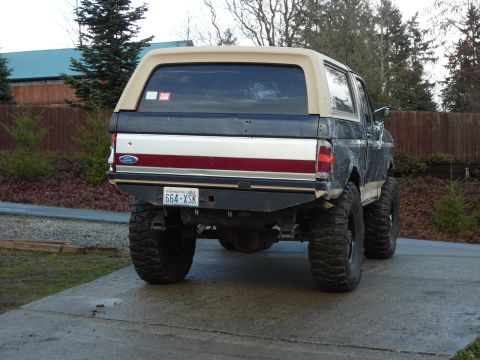 1991 Ford Bronco - Rear view of a lifted 1991 Ford Bronco with large off-road tires.