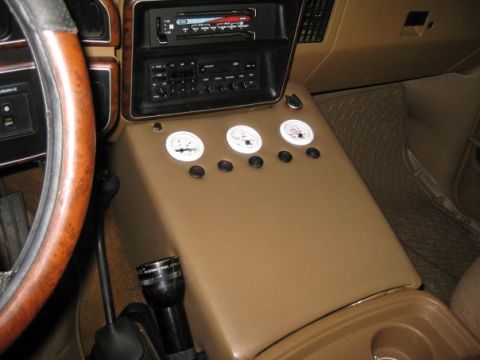 1909 Ford Bronco - The interior of a vehicle displays aftermarket gauges and a radio unit on the center console.