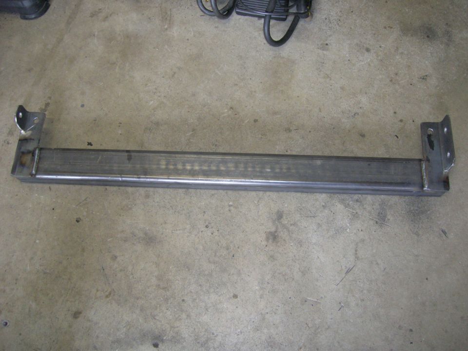 Metal bar with welded brackets on concrete floor