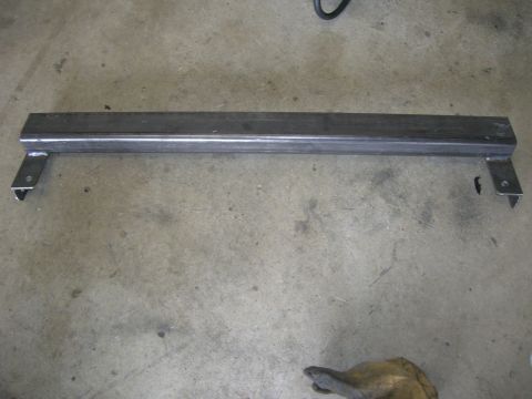 1996 Ford Bronco - A fabricated metal bar with mounting brackets is shown on a concrete surface.