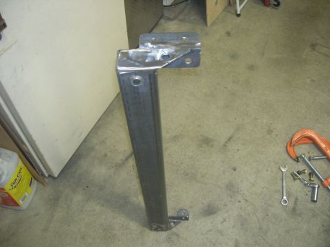 1996 Ford Bronco - A fabricated metal bracket with mounting holes sits on a garage floor.