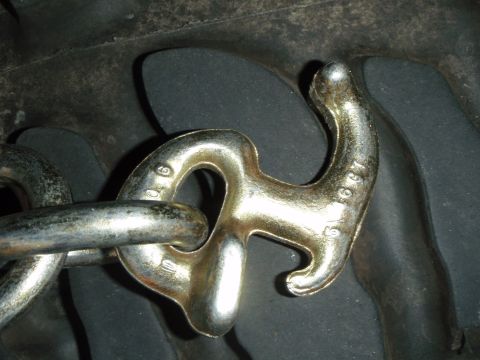 1995 Ford Bronco - Metal chain and hook with visible stamped numbers, likely a part.