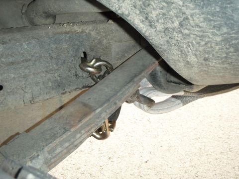 1995 Ford Bronco - Close-up view of a trailer hitch chain connected to the frame of a vehicle.