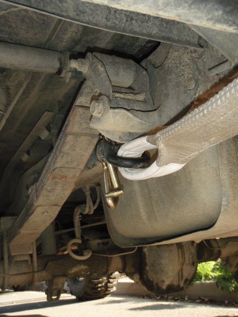 1995 Ford Bronco - Undercarriage detail with a tow strap connected to a shackle near the fuel tank.