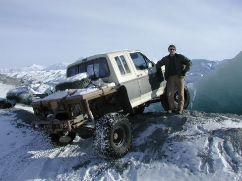 1990 Ford F-250 - A modified 1990 Ford F-250 sits on a snowy ridge with a man standing beside it.