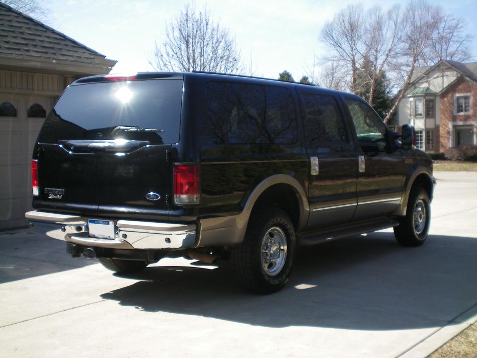 Black Ford Excursion SUV rear three-quarter view in a driveway
