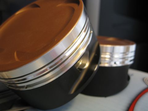 1994 Ford Probe - Close-up view of two engine pistons, highlighting their metallic construction and design details.