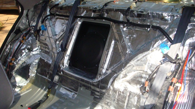 Rear bulkhead lined with foil sound deadening around a subwoofer opening