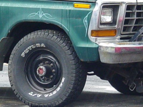 1992 Ford Bronco - Front fender and wheel of a Ford truck, likely from the late 1970s.