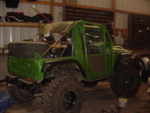 1992 Ford Bronco - This heavily modified off-road vehicle features a custom green body and a removable soft top.