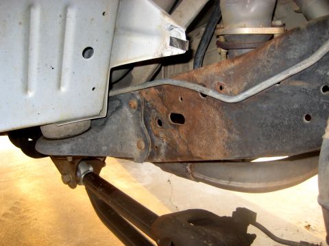 1996 Ford Bronco - Close-up view of heavily rusted vehicle frame and suspension components.