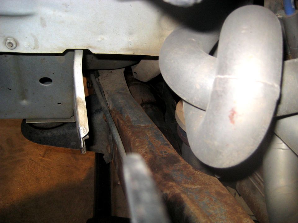 Close-up of exhaust pipes and rusty frame components