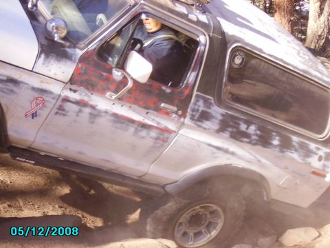 1978 Ford Bronco - This weathered Ford Bronco is navigating a rough, dusty trail with a driver inside.