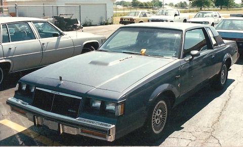 1978 Ford Bronco - A Buick Regal Grand National is parked in a lot with other vehicles visible.