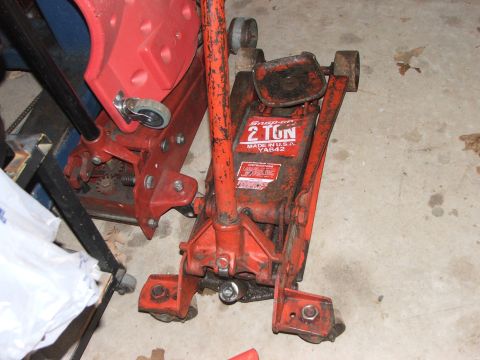 1965 Ford Mustang - A red Snap-on 2-ton floor jack is shown, with another red jack partially visible to the left.