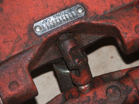 1965 Ford Mustang - This photo shows a close-up of a red metal component with a serial number and capacity plate attached.