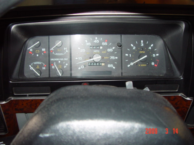 Instrument cluster of an older truck showing gauges and odometer