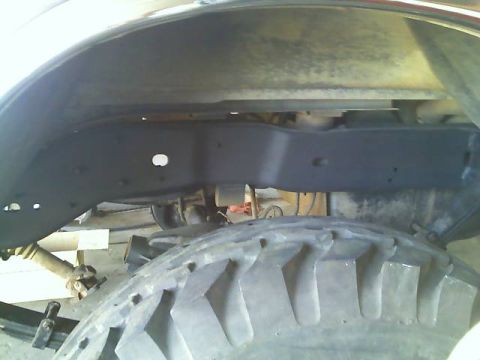 1996 Ford Bronco - Close-up view of a vehicle's undercarriage, focusing on the tire and chassis components.