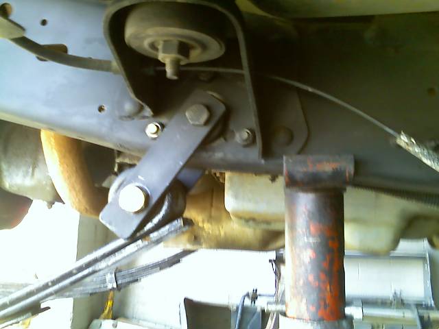 Undercarriage of a vehicle with suspension components and a jack.