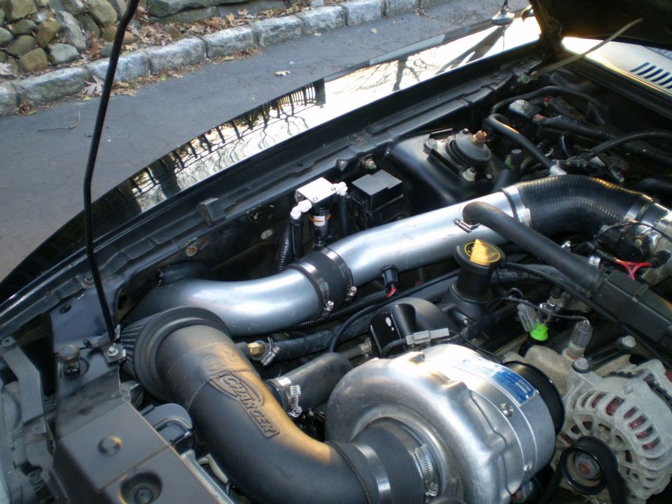 2002 Ford Mustang engine bay with supercharger and intake system