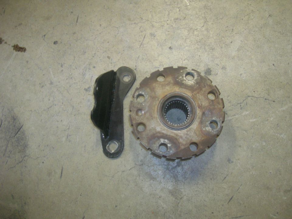 Rusty wheel hub and black metal bracket with rubber insert on concrete